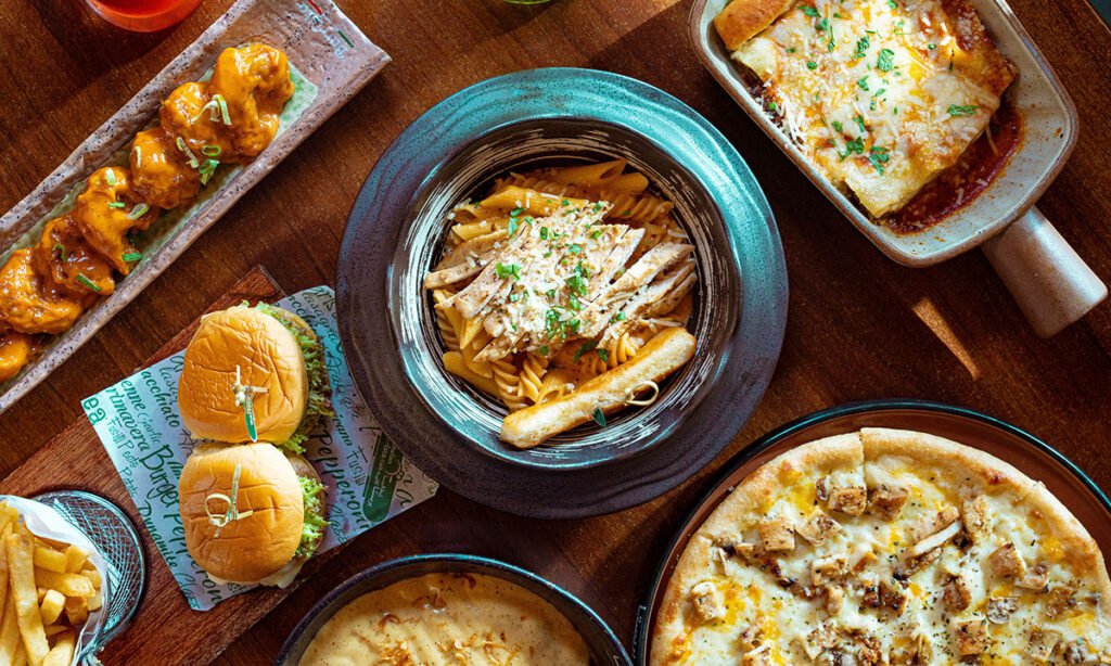 Assorted Italian dishes including pasta, lasagna, chicken pizza, and sliders served at an Italian restaurant