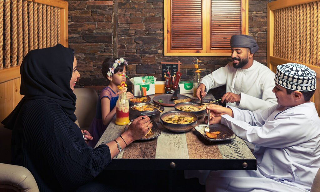 Family enjoying Italian food together at an Italian restaurant in Muscat.