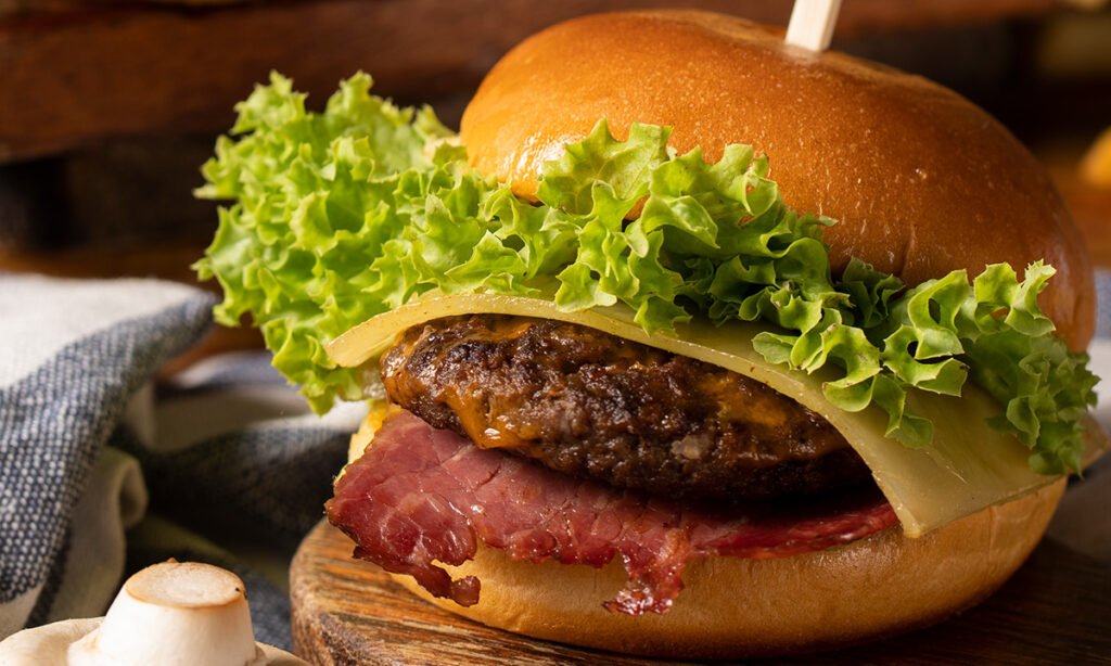 Juicy Machine Gun Burger with lettuce, pastrami, cheese, and beef patty served at an Italian restaurant
